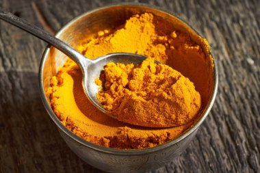 Kavanozdaki metal kaşıkta zerdeçal tozu.