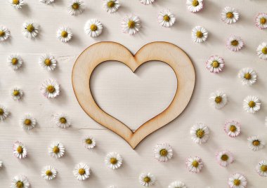 Beyaz zemin üzerinde papatya çiçekleri olan tahta kalp - Kopya alanı ile bahar kavramı