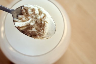 Sütlü protein tozunu bir bardak suya koymak, üst manzara.
