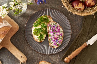 Sourdough bread with butter and wild edible spring plants - goutweed leaves, purple dead-nettle and lungwort flowers clipart