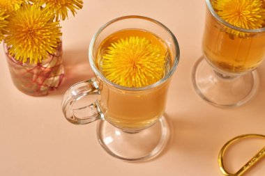 Baharda bir fincan bitki çayında karahindiba çiçekleri.