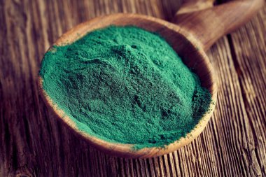 Masanın üzerindeki spirulina alg tozunun yakın çekimi - doğal vejetaryen gıda takviyesi
