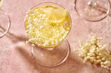 Pembe pastel arka planda taze yaşlı çiçekleriyle limonata. Bitkisel ya da alternatif tıp.