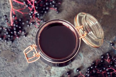 Cam bir kavanozda siyah yaşlı şurubu ve fres mürver, üst manzara.