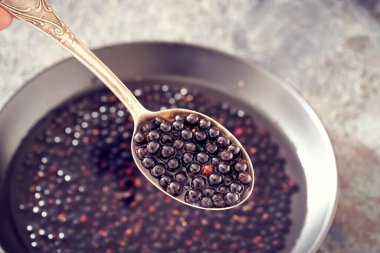 Bir kasenin üzerinde metal bir kaşık üzerinde mürver - ev yapımı siyah yaşlı şurubu hazırlama