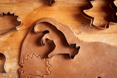 Zencefilli Noel kurabiyeleri hazırlamak için hamurdan hayvan şekilleri kesmek.