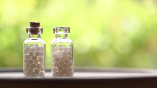 Dos Botellas Remedios Homeopáticos Pie Sobre Una Mesa Una Mano — Vídeo de stock