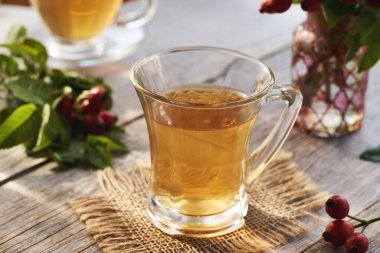Rose hip tea in a glass cup on a table