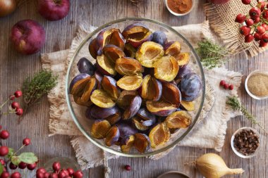 Pitted fresh plums, red apples, onions, ginger and spices - preparation of homemade chutney or relish, top view