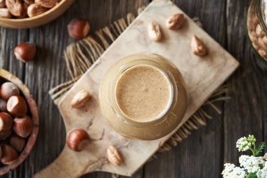 A jar of homemade hazelnut butter on a table, top view