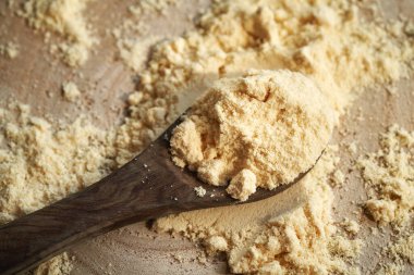 Tahta kaşıkta beyaz protein tozu, yakın çekim. Sağlıklı besin desteği.