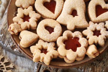 Bir tabak geleneksel ev yapımı Linzer Noel kurabiyesi marmelatla dolu ve şekerle kaplanmış.