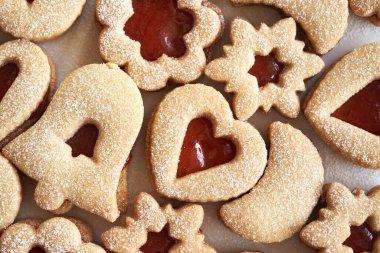 Ev yapımı Linzer Noel kurabiyelerinin üst görüntüsü çilekli marmelatla dolu ve şekerle kaplanmış