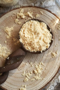 Masadaki tahta kaşıkta beyaz protein tozu, üst manzara. Sağlıklı besin desteği.