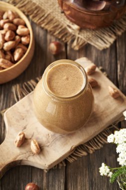 Masadaki cam kavanozda ev yapımı fındık ezmesi.