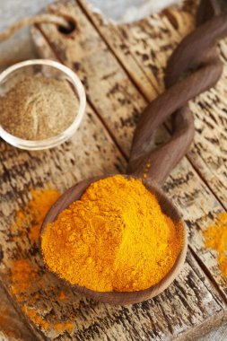 Kuru zerdeçal tozu ve ahşap bir masada bir kase karabiber.