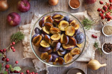 Sonbaharda toplanan taze çukur erikler, kırmızı elmalar, zencefil, soğan ve baharatlar - ev yapımı turşu ya da çeşni hazırlama