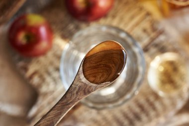 Elma sirkesi bir bardak suyun üstünde tahta bir kaşıkta.