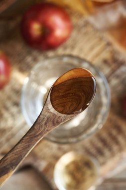 Elma sirkesi bir bardak suyun üstünde tahta bir kaşıkta.