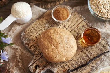 Süt tozu, yulaf ezmesi, akçaağaç pekmezi ve fındık ezmesinden yapılmış bir hamur topu. Ev yapımı atıştırmalık çikolataların hazırlanması.