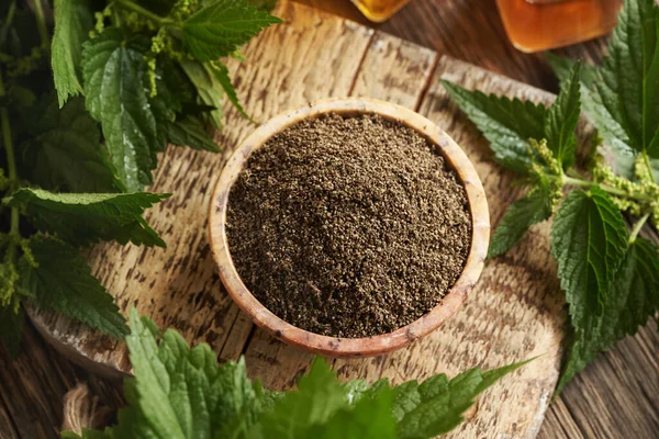 Kurutulmuş ısırgan otu tohumları ve masada taze yapraklar.