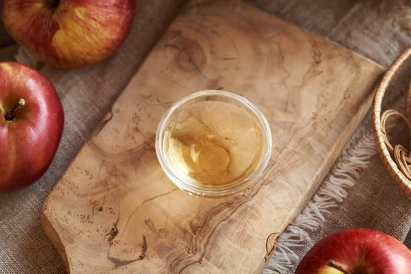 Bir kase elma sirkesi ve masada taze meyve.