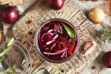 Taze pancar kökü, soğan, sarımsak ve baharattan yapılmış cam kavanozda mayalanmış pancar kvass hazırlama. Üst görünüm.