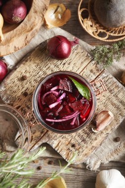 Taze pancar kökü, soğan, sarımsak ve baharattan cam kavanozda ev yapımı mayalanmış pancar kvass yapmak.