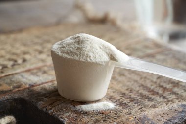 Masadaki plastik bir kaşık içindeki kolajen tozu.