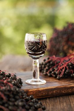 Bir bardak siyah ihtiyar ya da açık havada taze böğürtlenli Sambucus nigra şurubu.