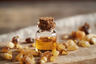 Ahşap bir masanın üzerinde bir şişe tütsü.