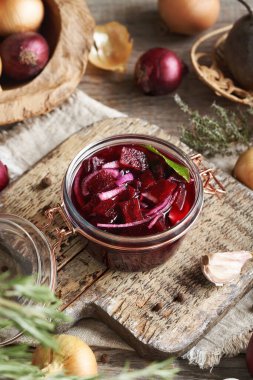 Masadaki cam kavanozda mayalanmış kırmızı pancar pancarı.