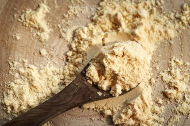 Masadaki kaşıkta beyaz protein tozu, üst manzara.