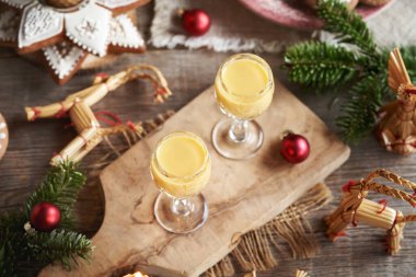 İki bardak zencefilli kurabiye, köknar ağacı dalları ve bir masada Noel süsü.