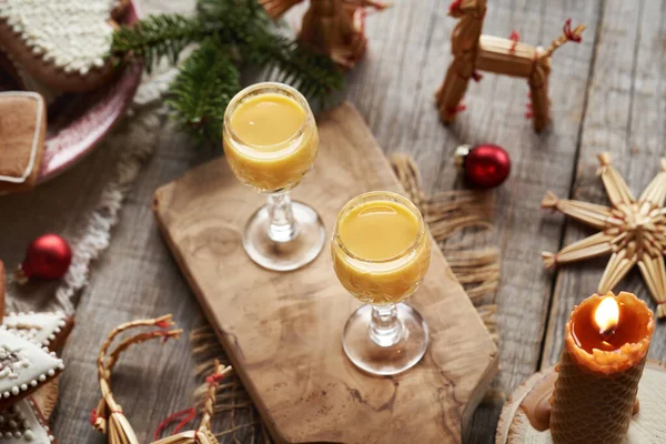 Cam bardaklarda zencefilli konyak ve ahşap bir masada Noel süslemesi.