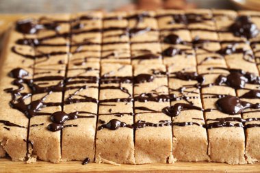 Beyaz protein tozu, badem unu, akçaağaç şurubu, fıstık ezmesi ve koyu çikolatadan yapılmış ev yapımı glütensiz atıştırmalıklar.