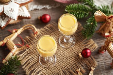 Eierkonyak, zencefilli kurabiye, saman süsleri ve bir masada Noel ağacı dalları