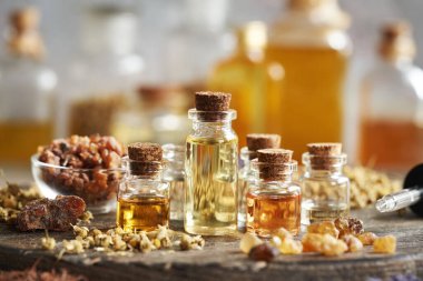 Cam şişelerde tütsü, merhem, kurutulmuş otlar ve çiçeklerle seçilen yağlar.