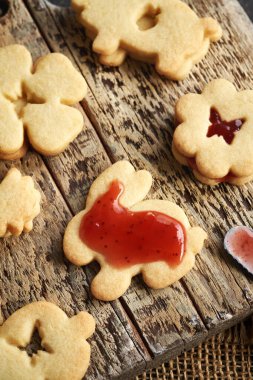 Tavşan şeklindeki Linzer Paskalya kurabiyelerini kırmızı çilekli marmelatla dolduruyorum.