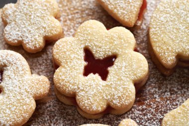 Çiçek şeklinde Paskalya kurabiyesi kırmızı marmelatla doldurulmuş ve şekerle tozlanmış.