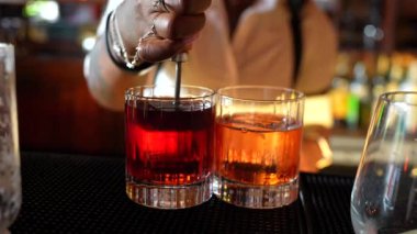 Barda kırmızı kokteyl hazırlayan bir mixolog.