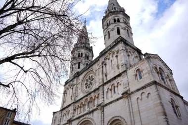 İkiz kuleleri ve mavi gökyüzünün altında Macon Fransa 'da kemerli girişi olan eski taş bir katedral.