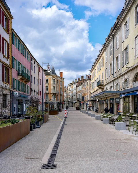 Kafeleri ve bulutların altında boş yaya yolu olan eski, parlak bir şehir mimarisi.