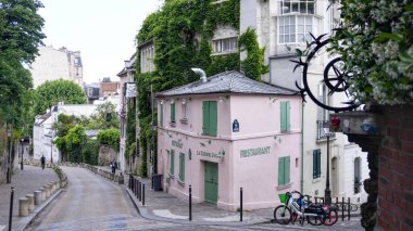 Fransa 'nın Montmartre bölgesindeki Rue de lAbreuvoir' da bulunan tarihi pembe restoran La Maison Rose manzaralı..