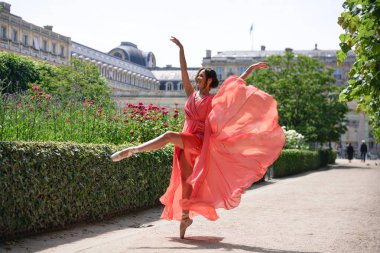 Tarihi mimariyle birlikte yaz parkında sahne alan zarif bir balerin.