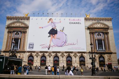 İnsanlar, Palais Garnier opera binasında büyük Chanel moda ilanlarının yakınında toplandı. 