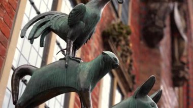 Bremen Kasabası Müzisyenlerinin, Bremen Almanya 'sında tuğla duvara karşı duran horoz ve kedi figürlerini gösteren bronz heykelinin detaylarını kapatın. 