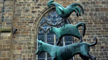 Bremen Kasabası Müzisyenleri 'nin kapısında Bremen Almanya' sında tuğla duvara karşı duran horoz ve kedi figürlerini gösteren bronz heykel 