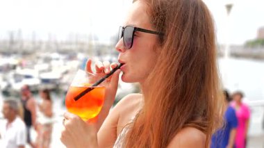 Liman yatı Gijon İspanya 'da portakal suyu yudumlayan bir kadın.