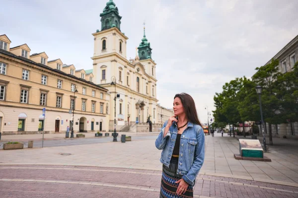 Varşova Polonya 'daki eski kilisenin yanında yaz gününün tadını çıkaran kadın.